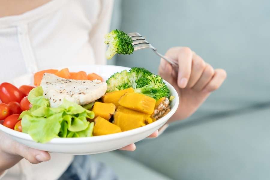 Une personne tenant une assiette composée de légumes variés pour la diversification alimentaire.